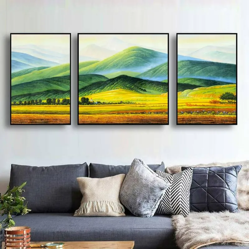 Một bộ ba bức tranh in canvas treo tường, mô tả những ngọn núi xanh mờ ảo và cánh đồng lúa vàng, tạo cảm giác yên bình, nhẹ nhàng