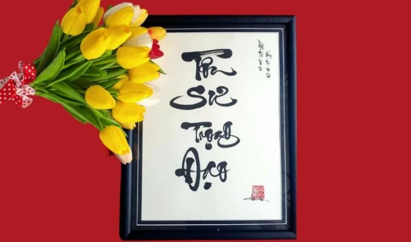 Bức tranh thư pháp "Tôn sư trọng đạo" kèm bó hoa tulip tượng trưng cho tình cảm tôn kính và sự tri ân