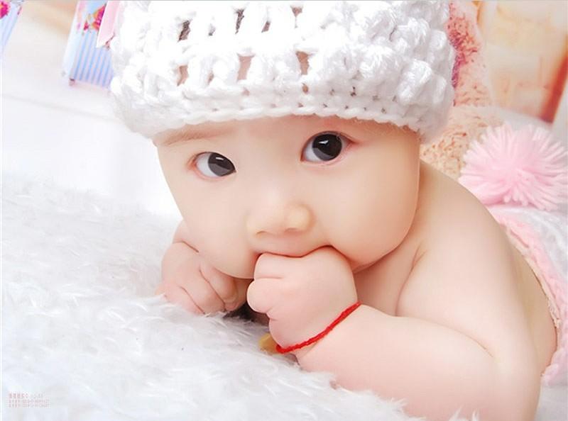 Tranh em bé treo phòng ngủ bé đội mũ len trắng nằm sấp mang lại năng lượng yêu thương