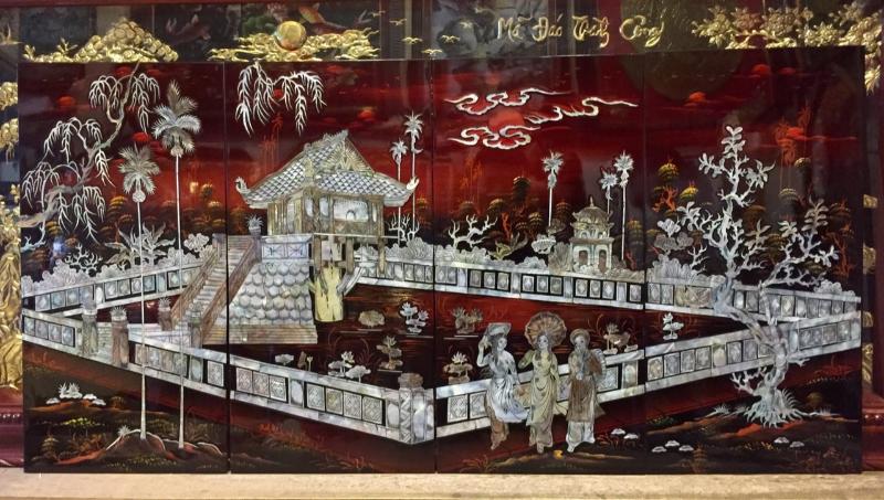 Một bức tranh sơn mài khảm trai đề tài kiến trúc cổ và sinh hoạt truyền thống.