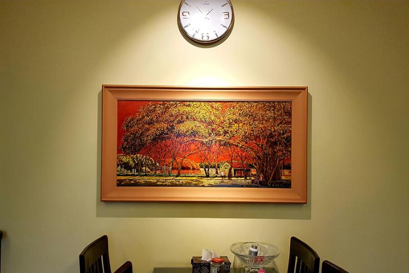 Tranh sơn mài phong cảnh cây đa làng quê dưới ánh chiều hoàng hôn rực rỡ, mang lại sự ấm cúng và chiều sâu