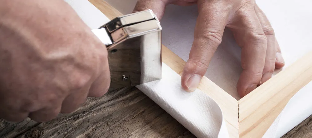 Thợ lành nghề Artnam tiến hành căng tranh tràn viền lên khung gỗ sồi