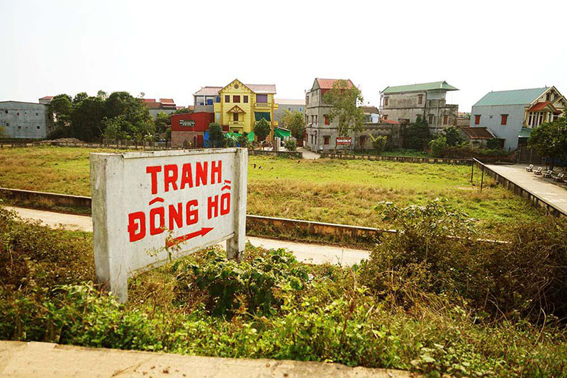 Biển chỉ dẫn bằng bê tông sơn chữ đỏ hướng dẫn đường đi vào làng tranh Đông Hồ Bắc Ninh