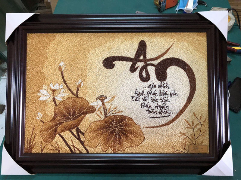 Tranh gạo thư pháp chữ An kết hợp hoa sen và họa tiết nền từ hạt gạo rang nhiều sắc độ